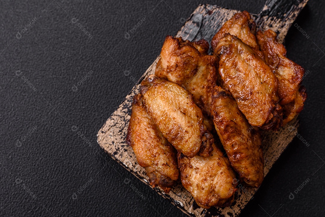 Asas de frango assadas saborosas em uma mesa de concreto