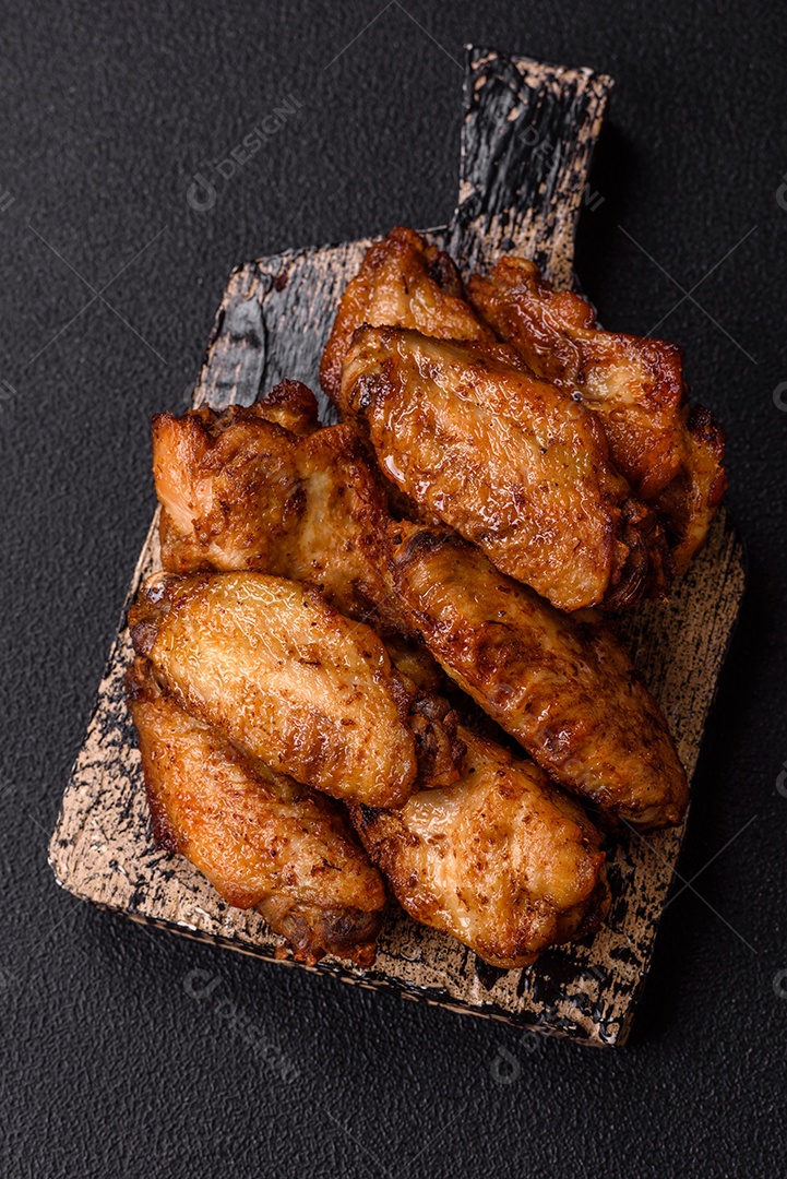 Asas de frango assadas saborosas em uma mesa de concreto