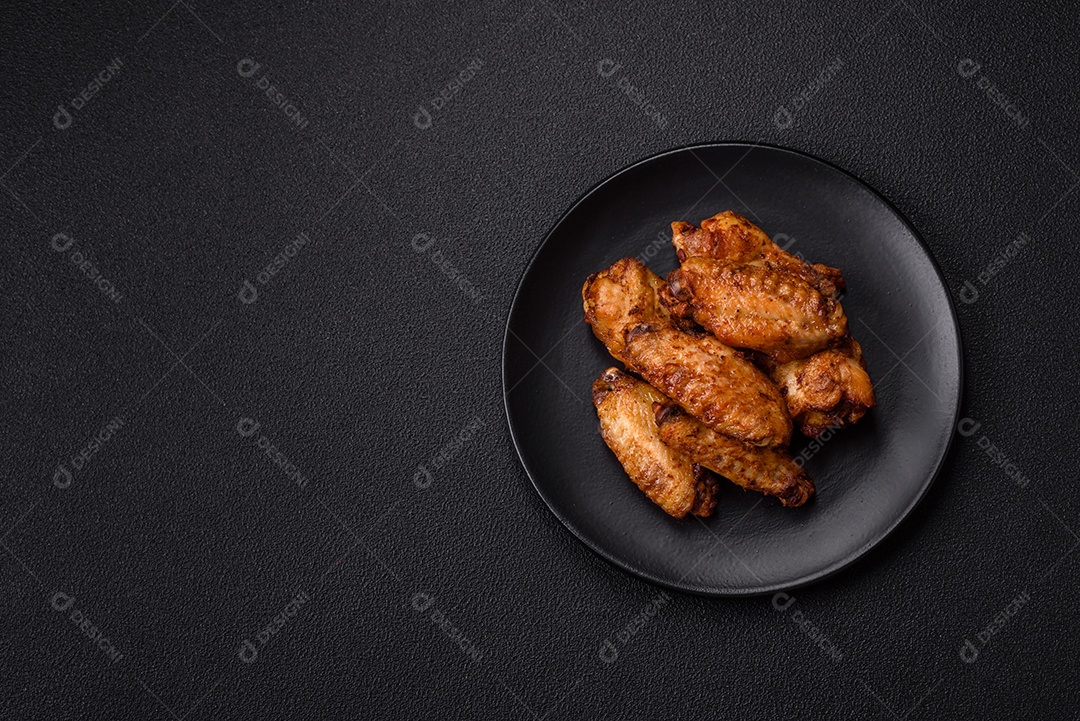Asas de frango assadas saborosas em uma mesa de concreto