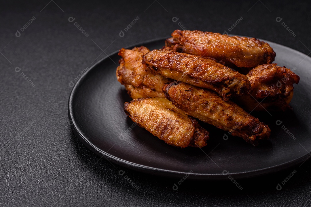 Asas de frango assadas saborosas em uma mesa de concreto