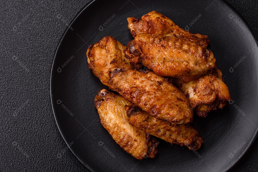 Asas de frango assadas saborosas em uma mesa de concreto
