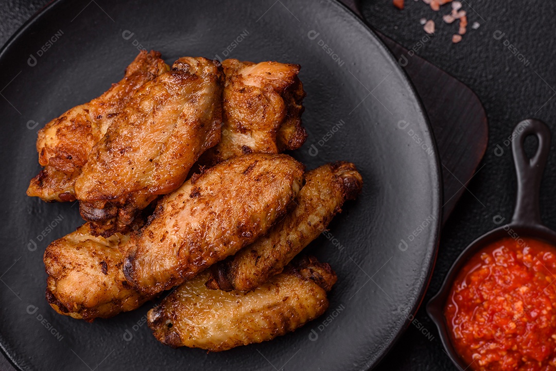 Asas de frango assadas saborosas em uma mesa de concreto