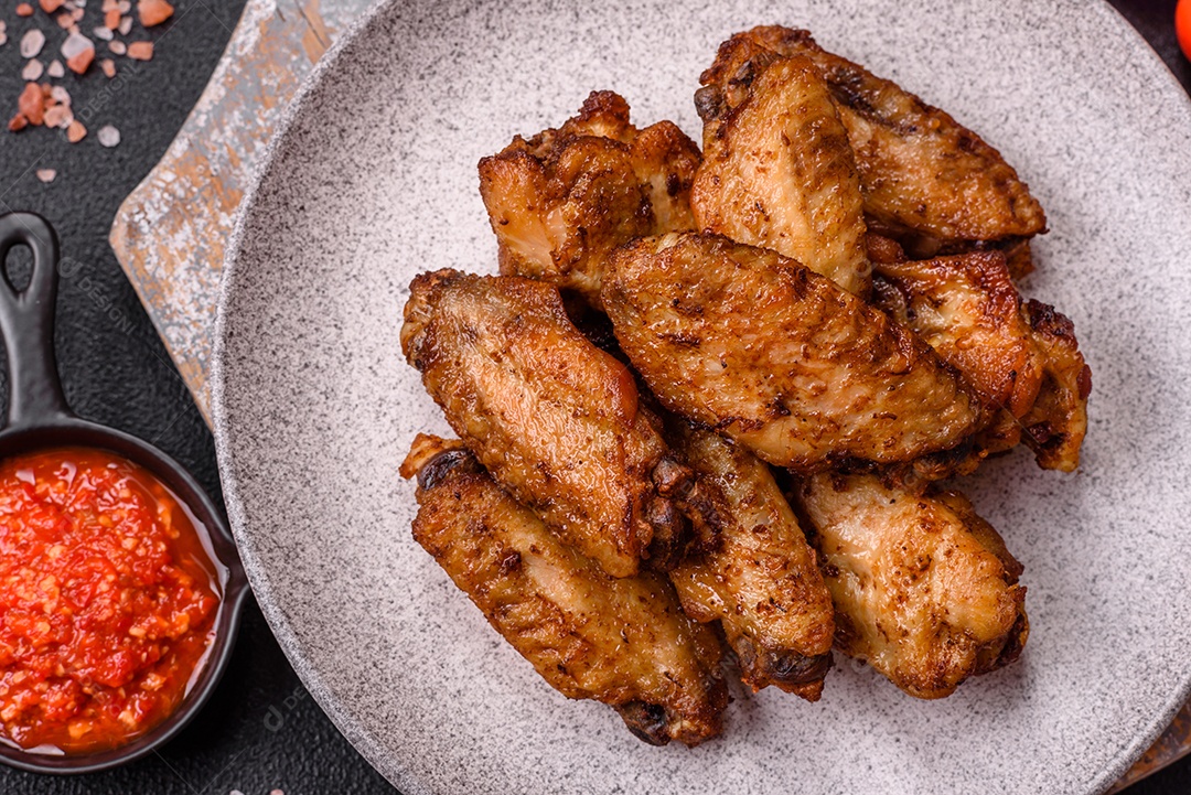 Asas de frango assadas saborosas em uma mesa de concreto