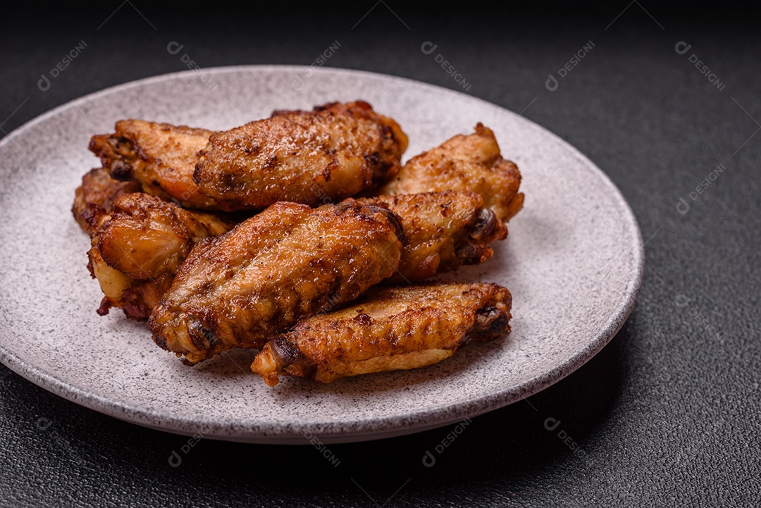 Asas de frango assadas saborosas em uma mesa de concreto