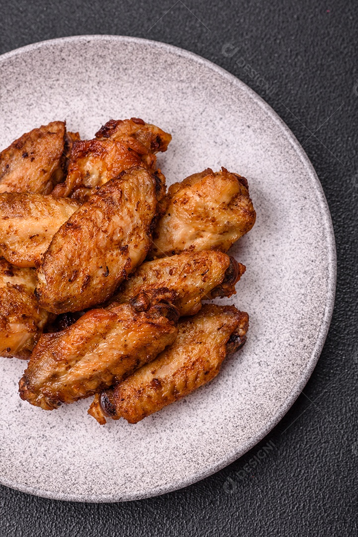 Asas de frango assadas saborosas em uma mesa de concreto