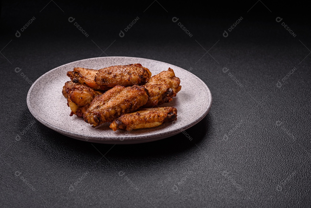 Asas de frango assadas saborosas em uma mesa de concreto