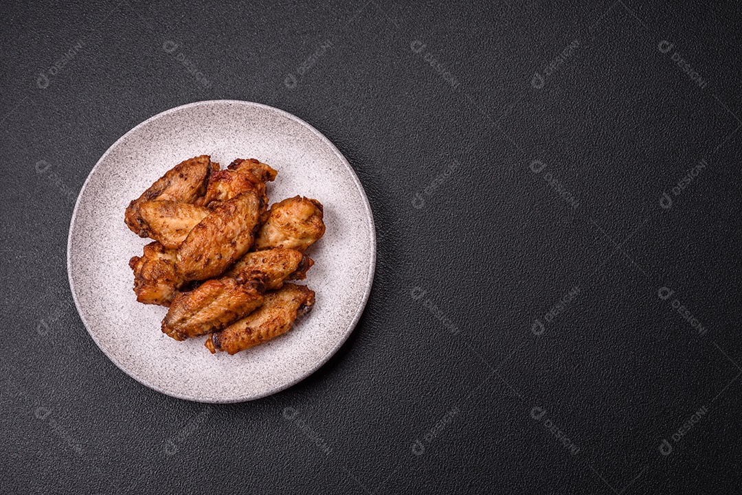 Asas de frango assadas saborosas em uma mesa de concreto