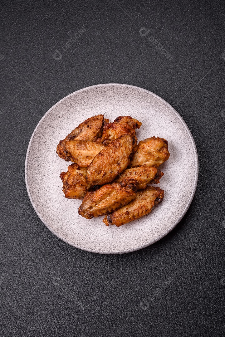 Asas de frango assadas saborosas em uma mesa de concreto