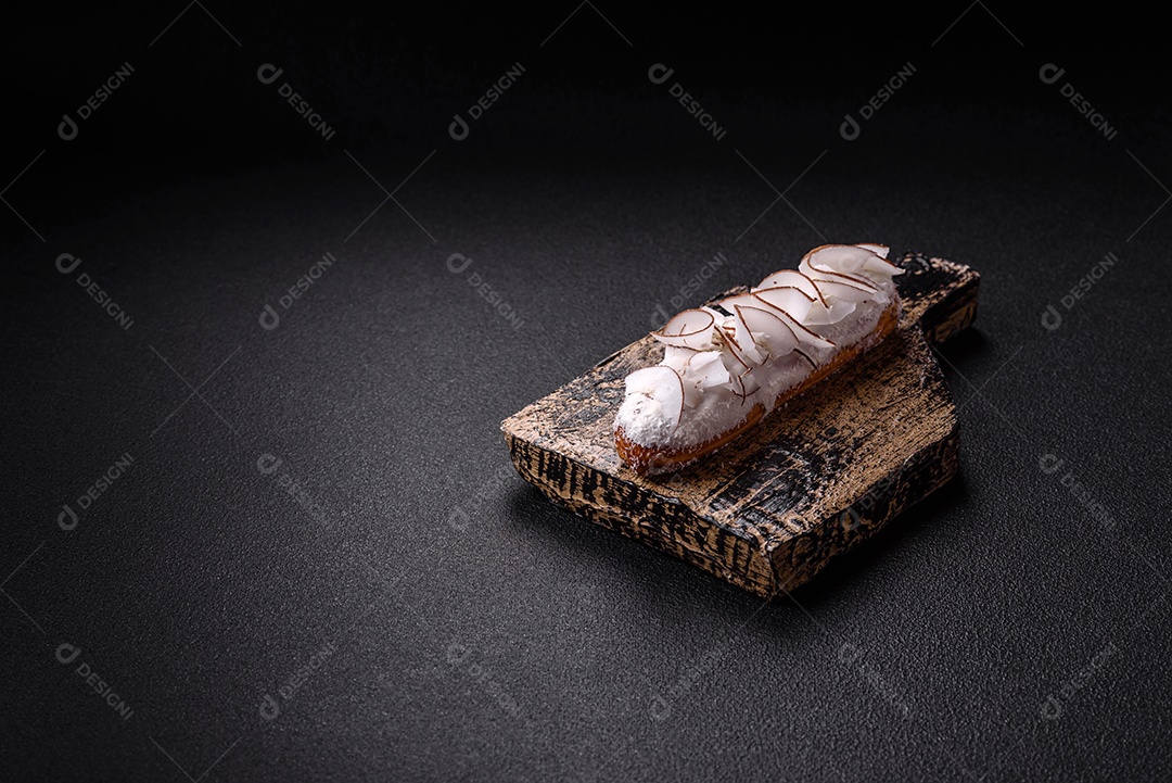 Éclair doce com creme decorado com fatias de coco