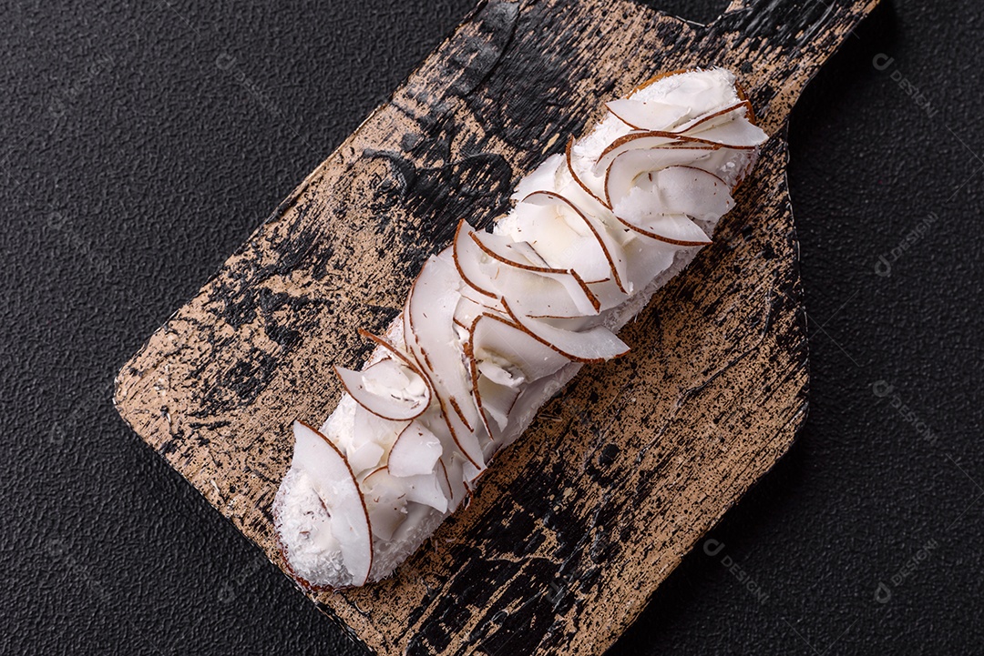 Éclair doce com creme decorado com fatias de coco