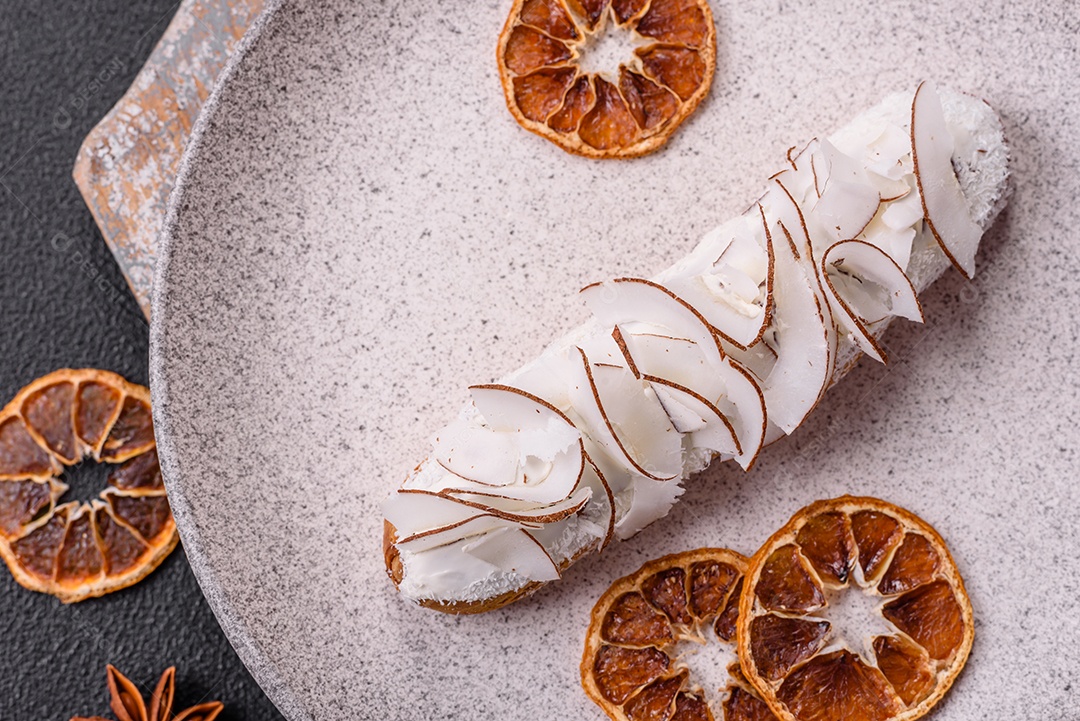 Éclair doce com creme decorado com fatias de coco
