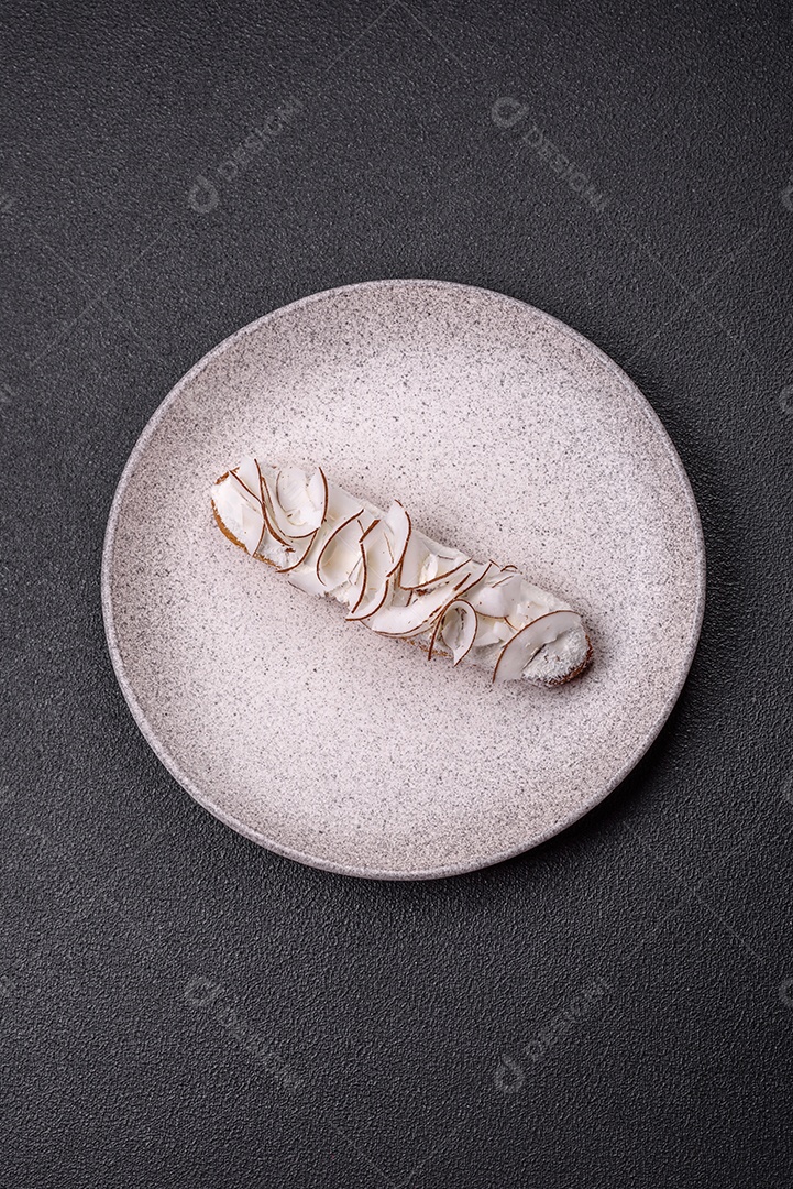 Éclair doce com creme decorado com fatias de coco