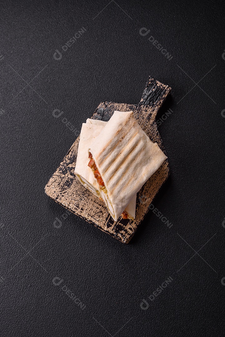 Imagem mostra dois wraps ou shawarmas cortados ao meio e servidos em um prato