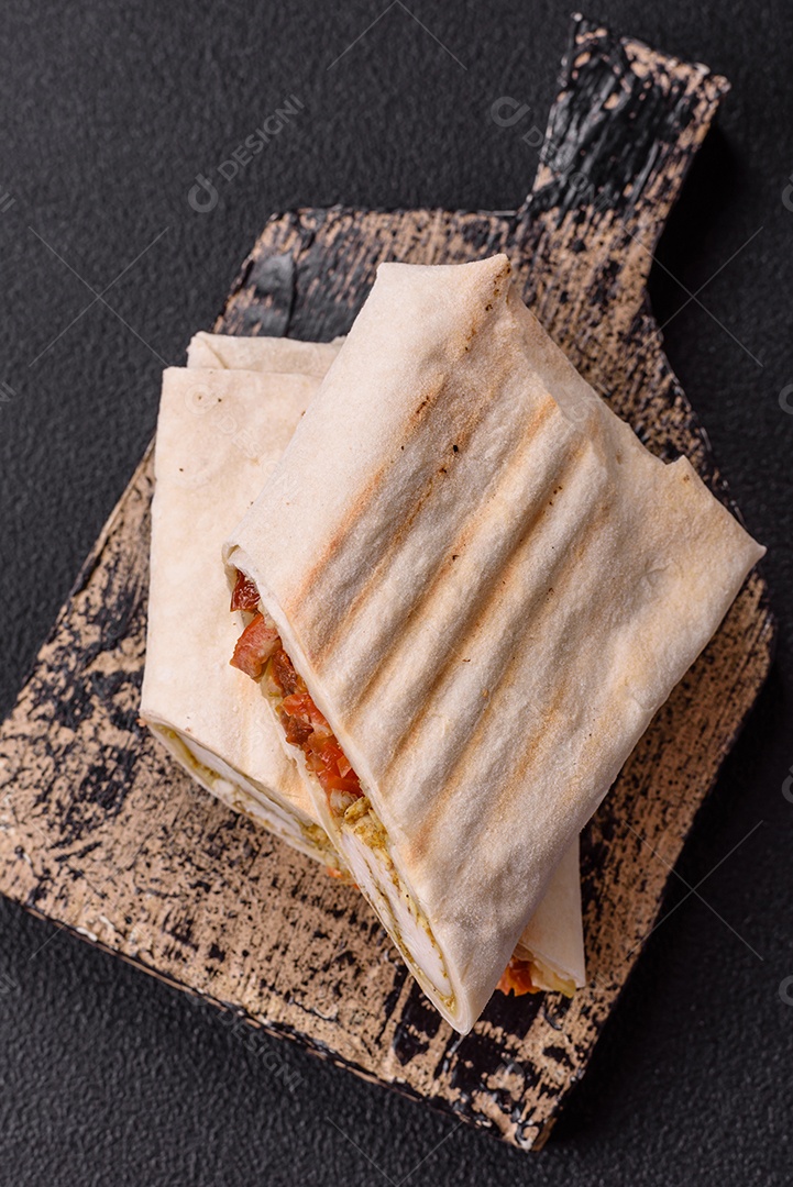 Imagem mostra dois wraps ou shawarmas cortados ao meio e servidos em um prato