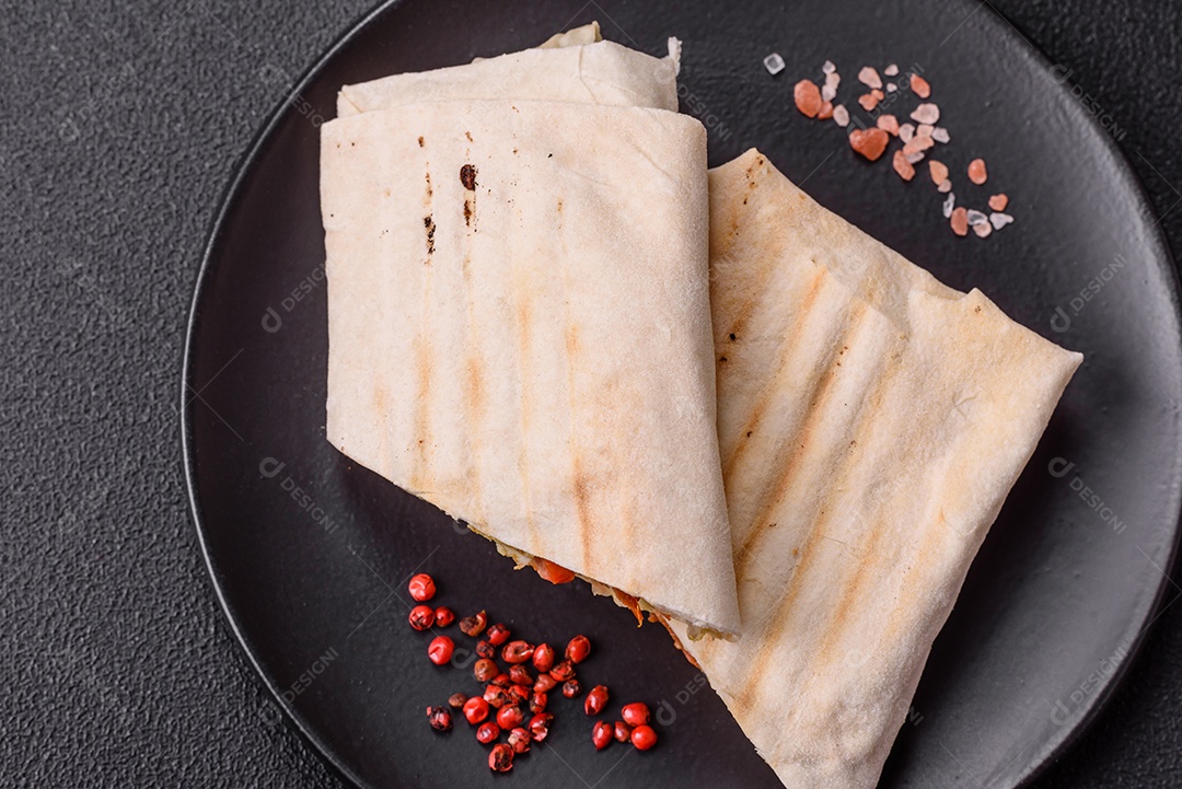 Imagem mostra dois wraps ou shawarmas cortados ao meio e servidos em um prato