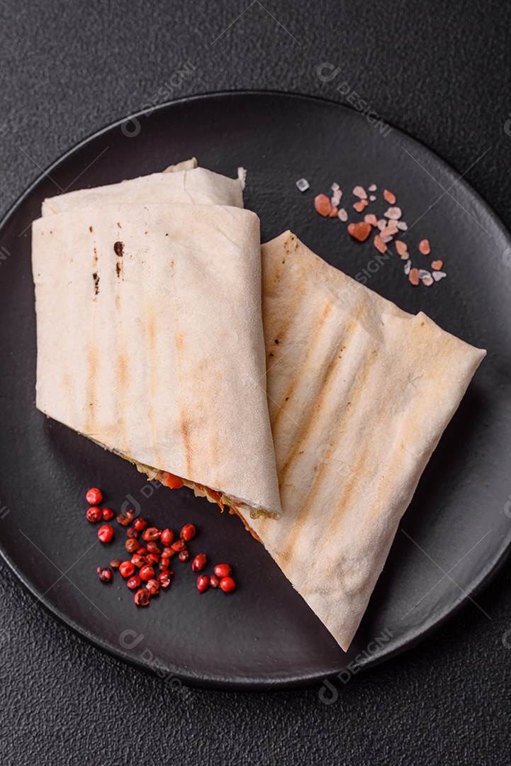 Imagem mostra dois wraps ou shawarmas cortados ao meio e servidos em um prato