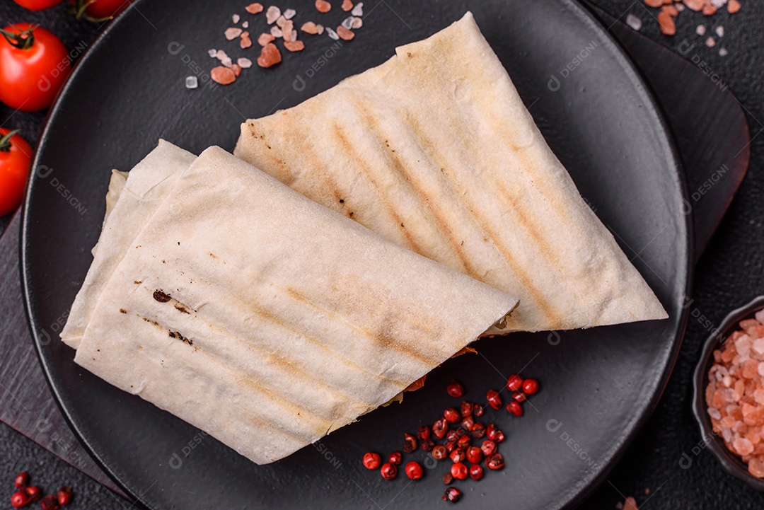 Imagem mostra dois wraps ou shawarmas cortados ao meio e servidos em um prato