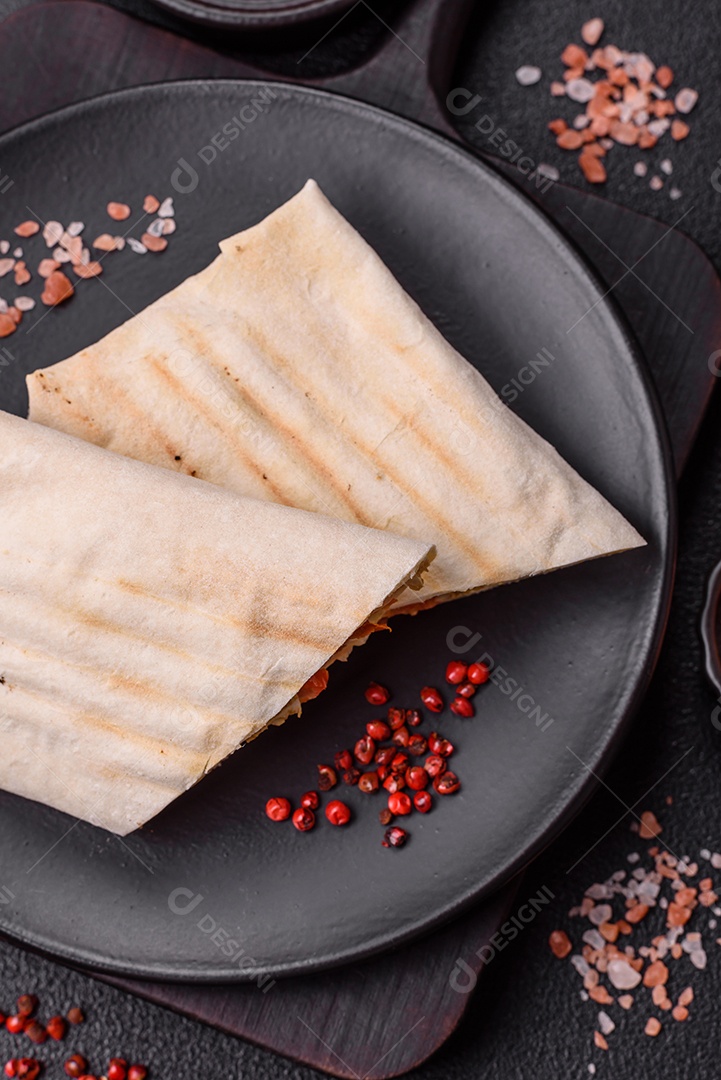 Imagem mostra dois wraps ou shawarmas cortados ao meio e servidos em um prato