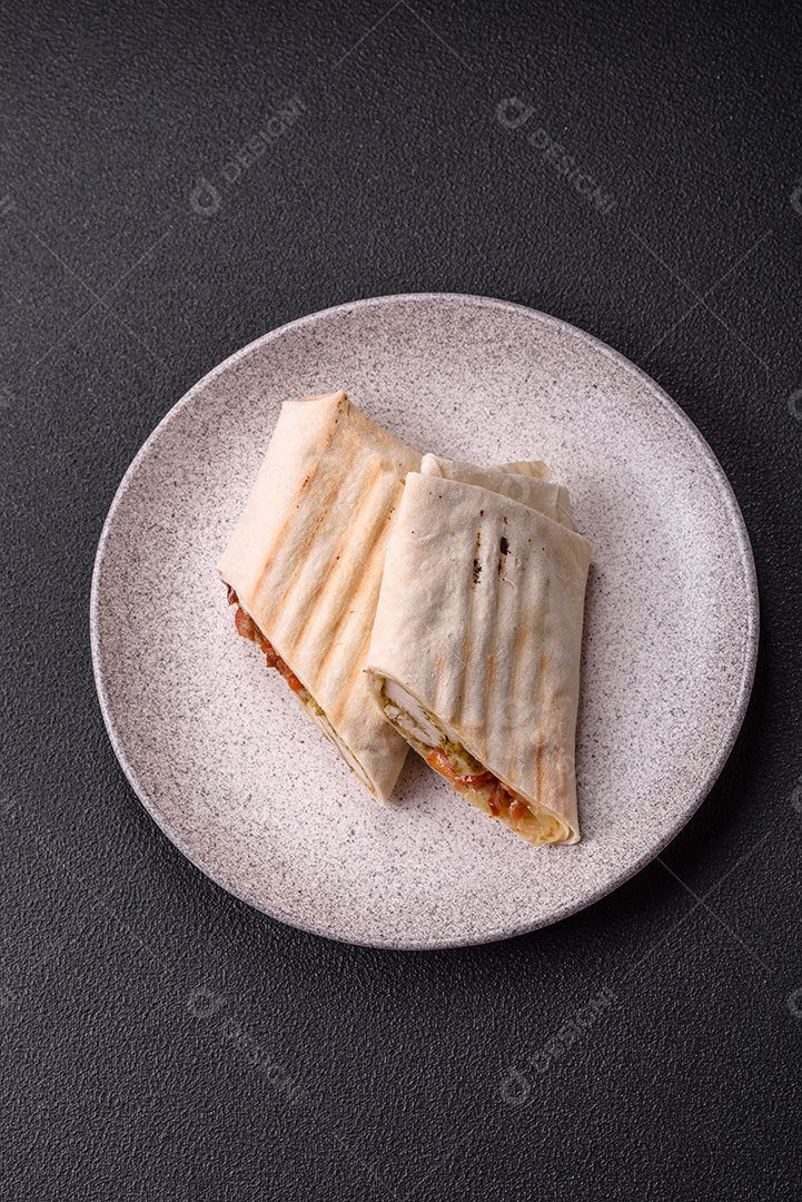 Imagem mostra dois wraps ou shawarmas cortados ao meio e servidos em um prato