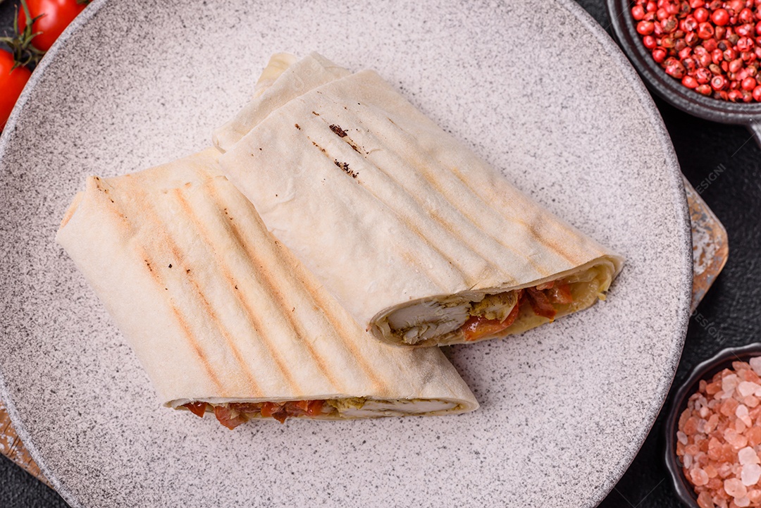 Imagem mostra dois wraps ou shawarmas cortados ao meio e servidos em um prato
