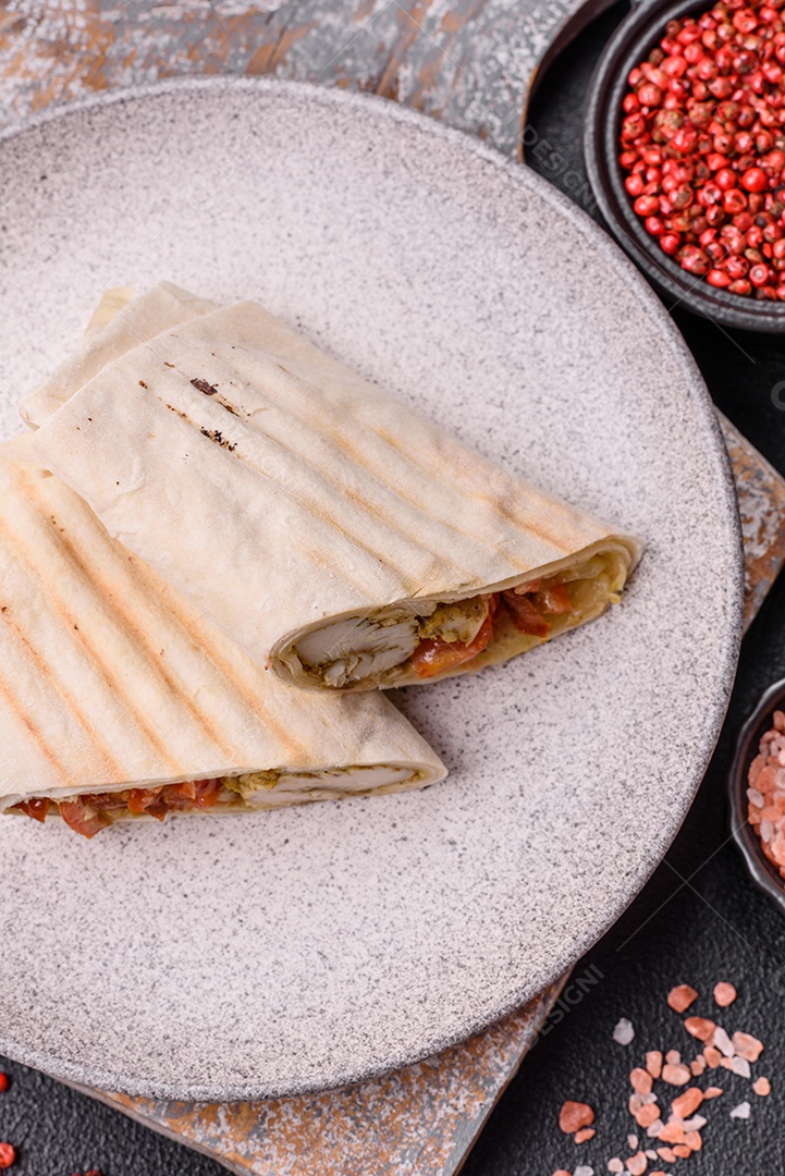 Imagem mostra dois wraps ou shawarmas cortados ao meio e servidos em um prato