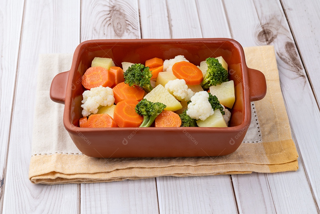 Imagem mostra uma travessa de cerâmica contendo uma variedade de vegetais cozidos no vapor ou assados