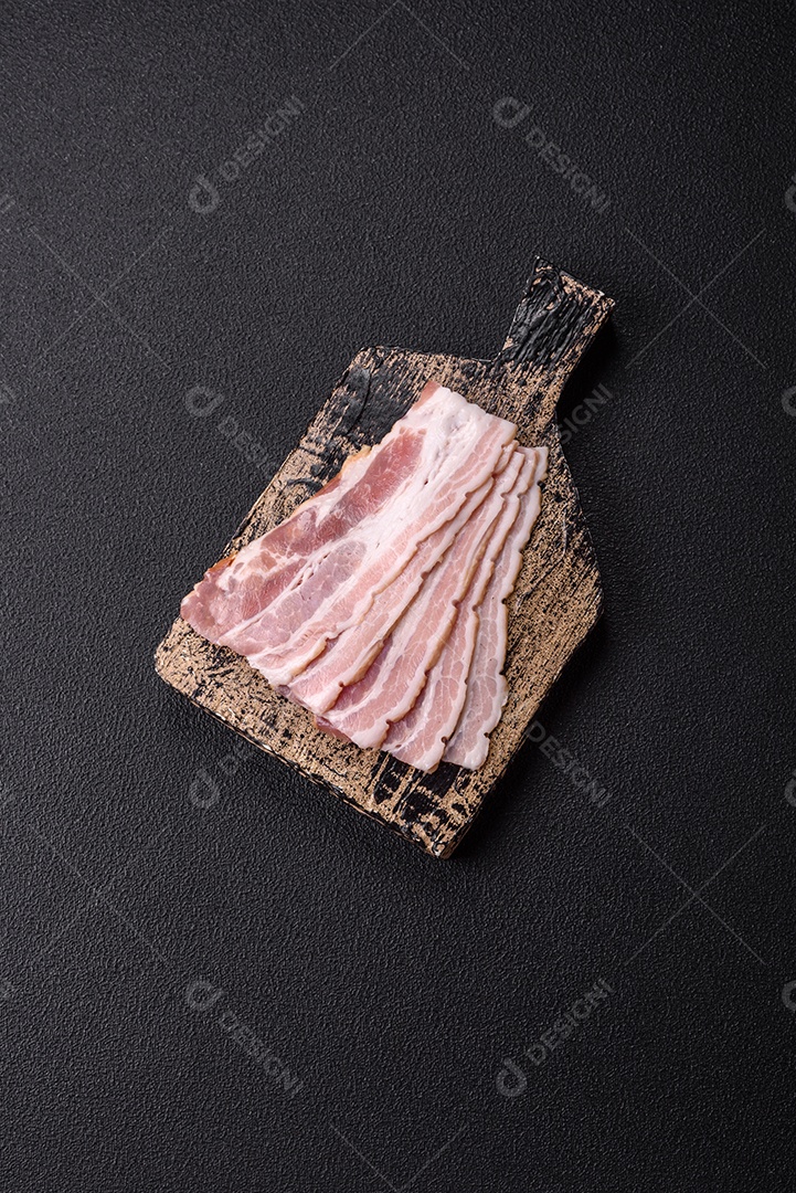 Imagem mostra fatias de bacon cru, acompanhadas de tomates cereja e sal rosa.