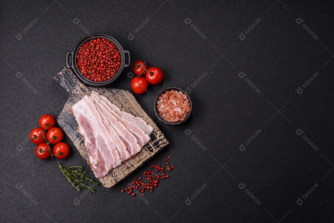 Imagem mostra fatias de bacon cru, acompanhadas de tomates cereja e sal rosa