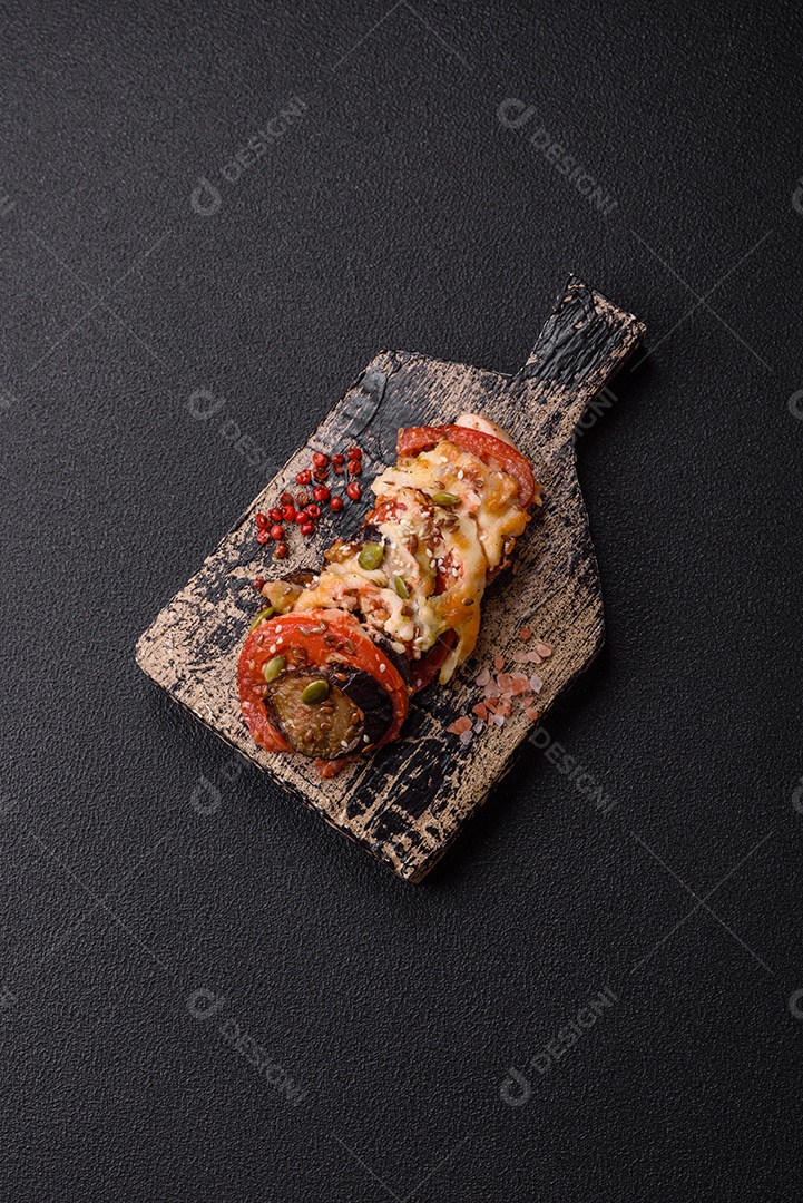 Imagem mostra berinjelas preparadas, tomates frescos e um molho à base de tomate