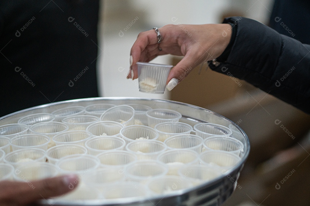 Mão de uma mulher pegando santa ceia em uma bandeija sob uma igreja