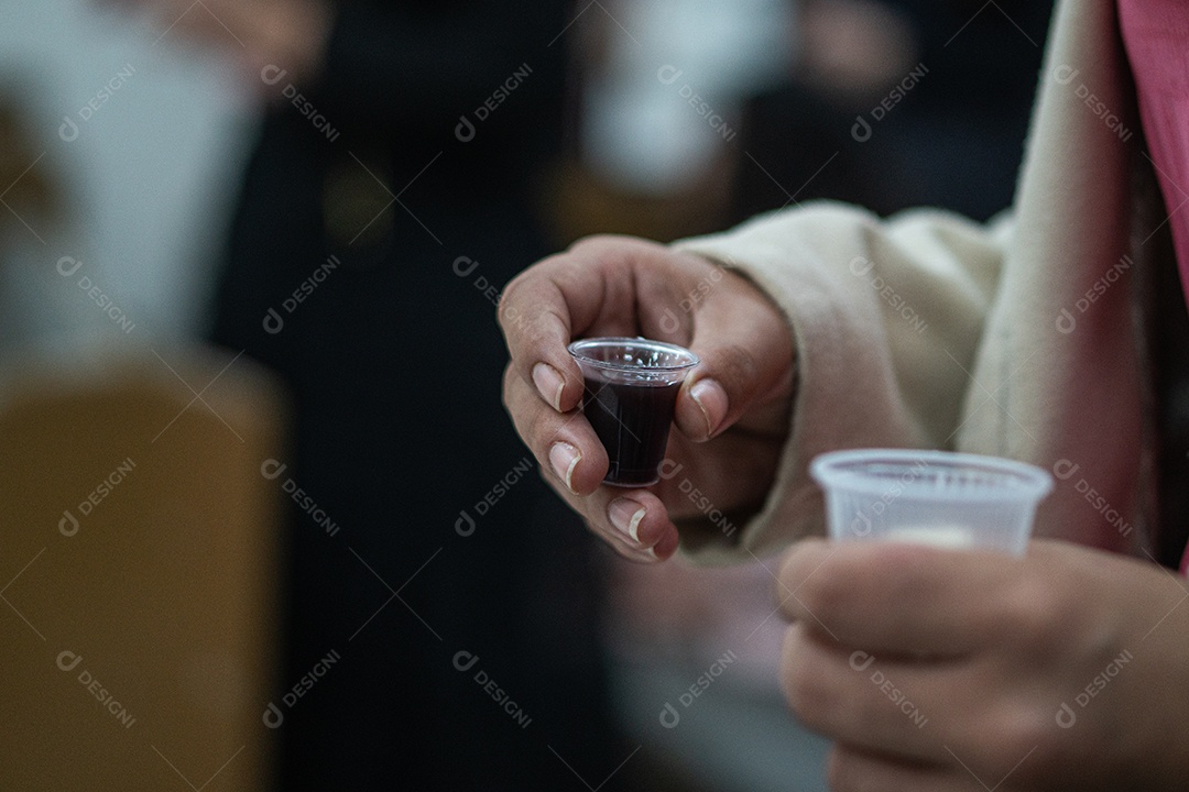 Mão de uma mulher segurando santa ceia sob uma igreja