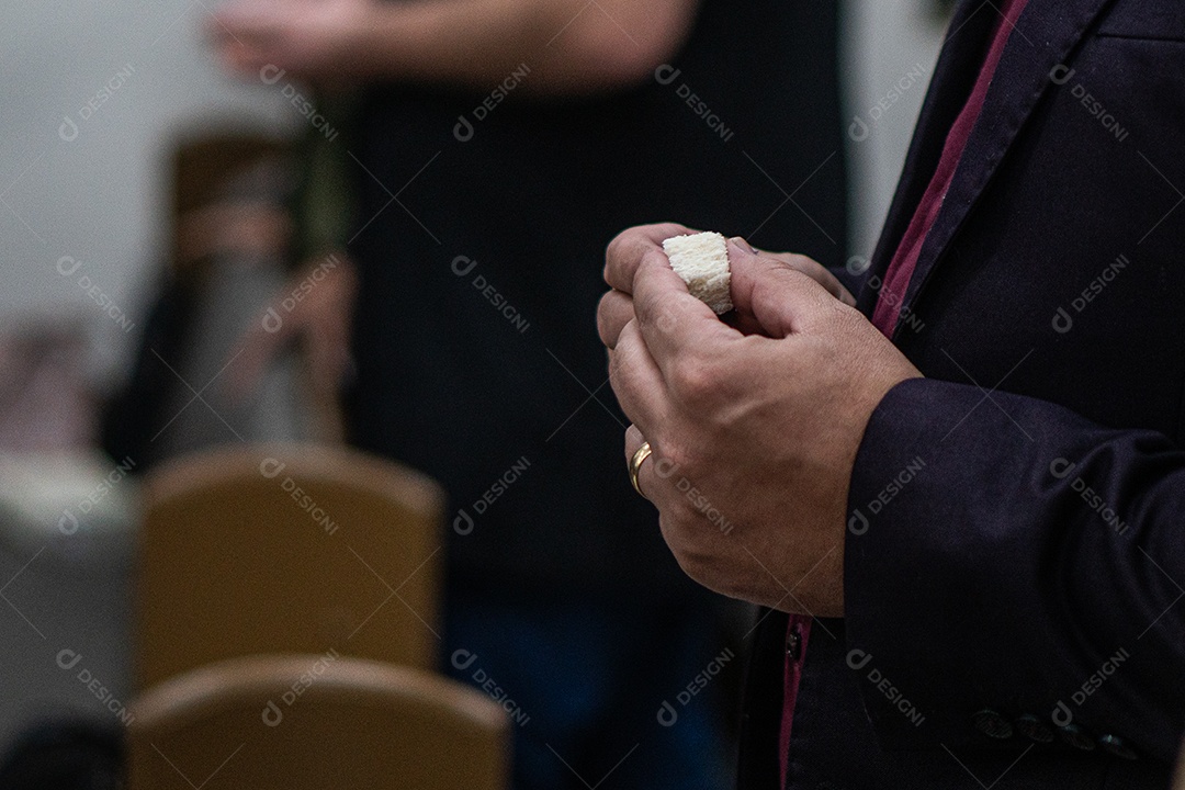 Mão de uma mulher segurando santa ceia sob uma igreja
