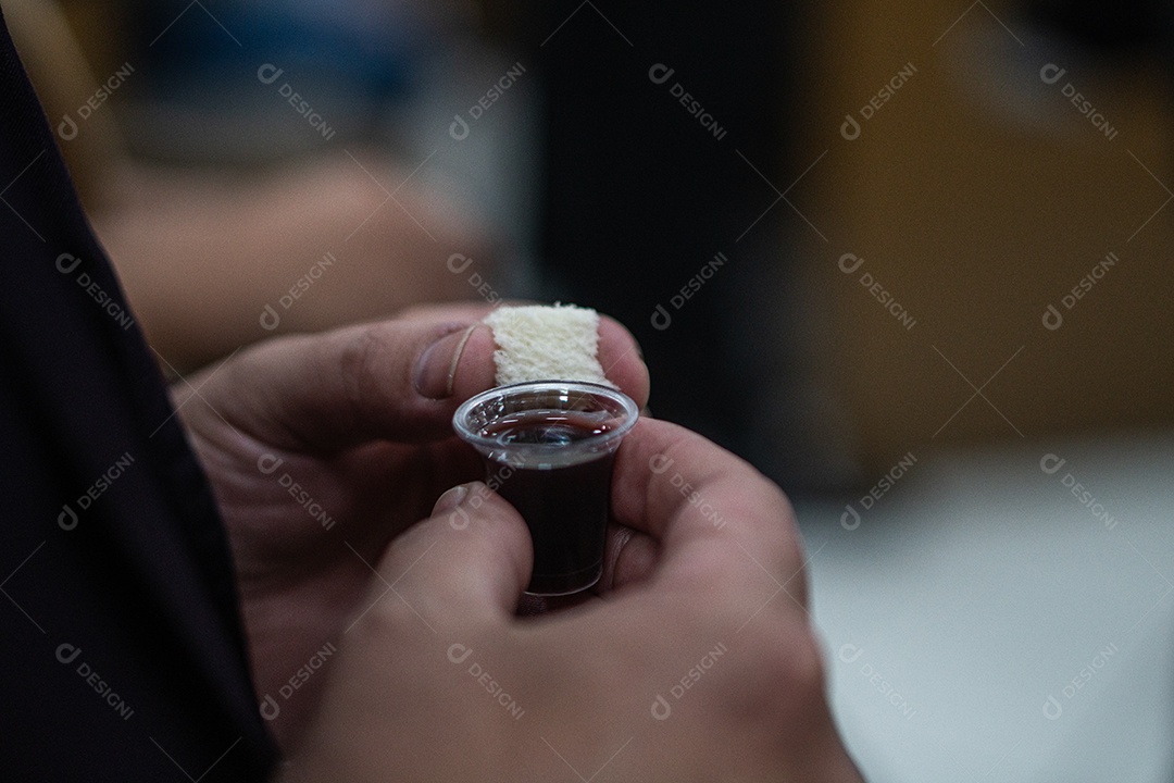 Mão de uma mulher segurando santa ceia sob uma igreja