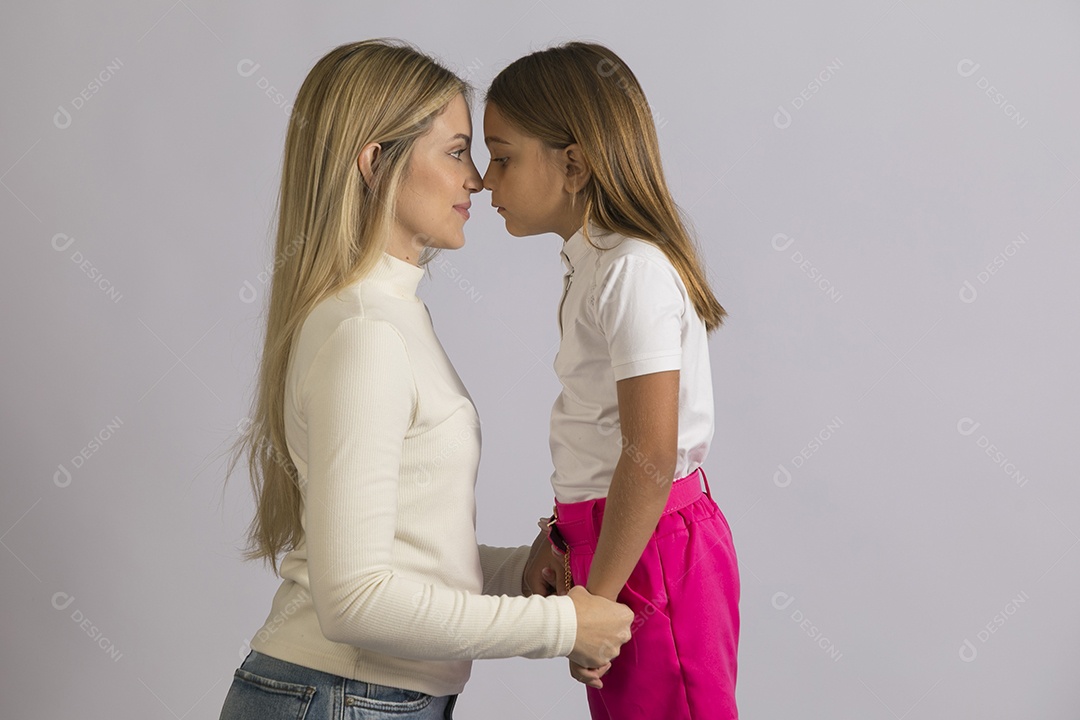 Linda mãe jovem ao lado de sua filha fundo isolado branco