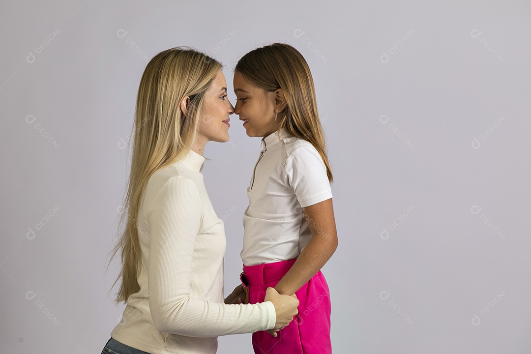 Linda mãe jovem ao lado de sua filha fundo isolado branco