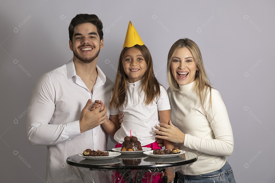 Pais ao lado de sua filha celebrando aniversário sobre fundo isolado branco