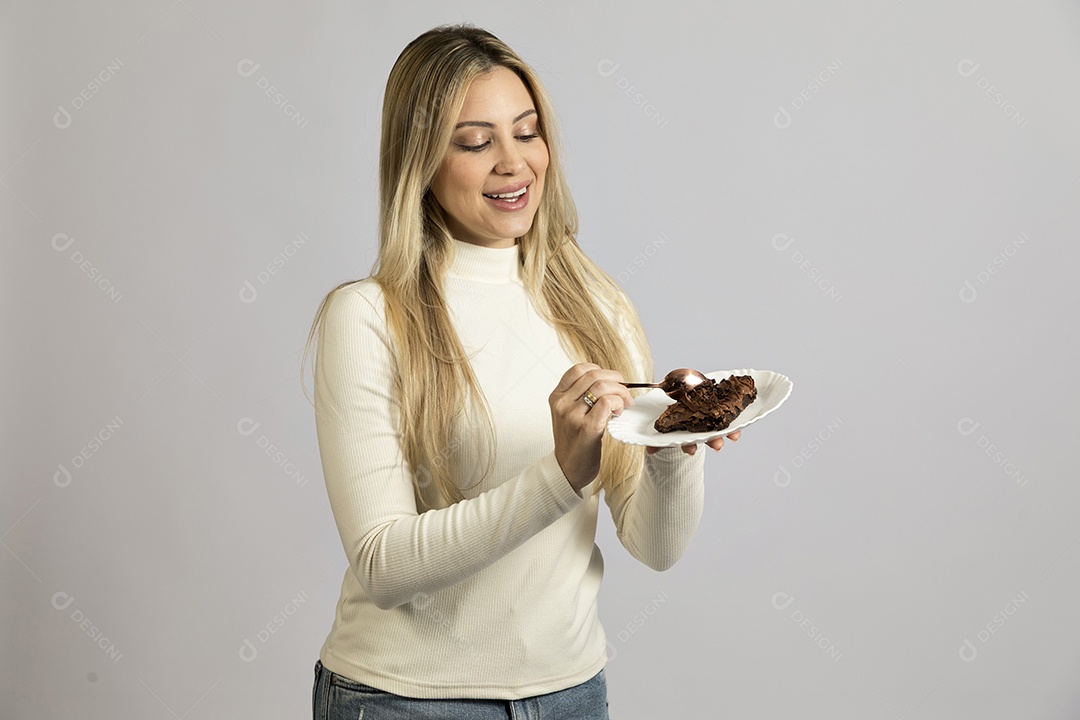 Mulher jovem bonita comendo bolo sobre fundo isolado branco