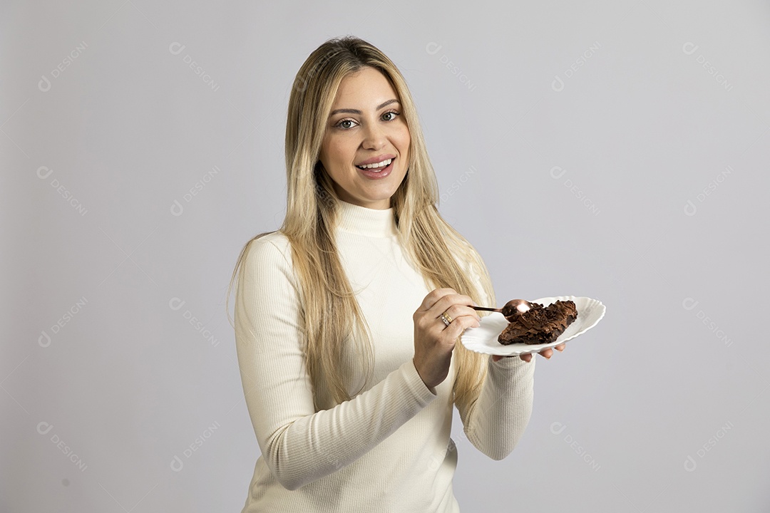 Mulher jovem bonita comendo bolo sobre fundo isolado branco