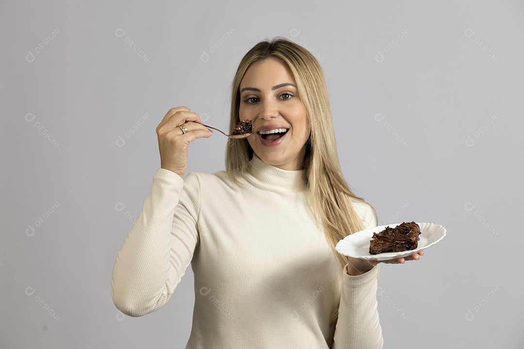 Mulher jovem bonita comendo bolo sobre fundo isolado branco