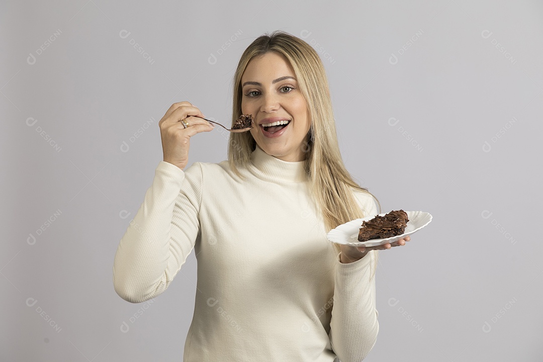 Mulher jovem bonita comendo bolo sobre fundo isolado branco