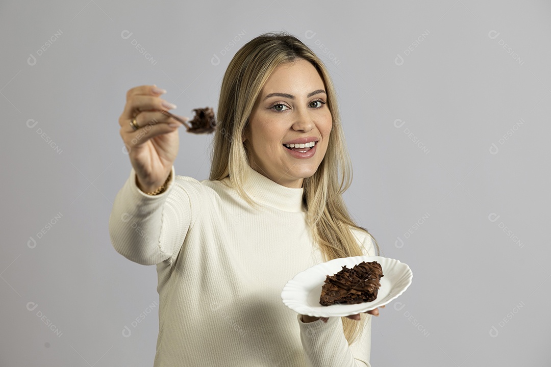 Mulher jovem bonita comendo bolo sobre fundo isolado branco