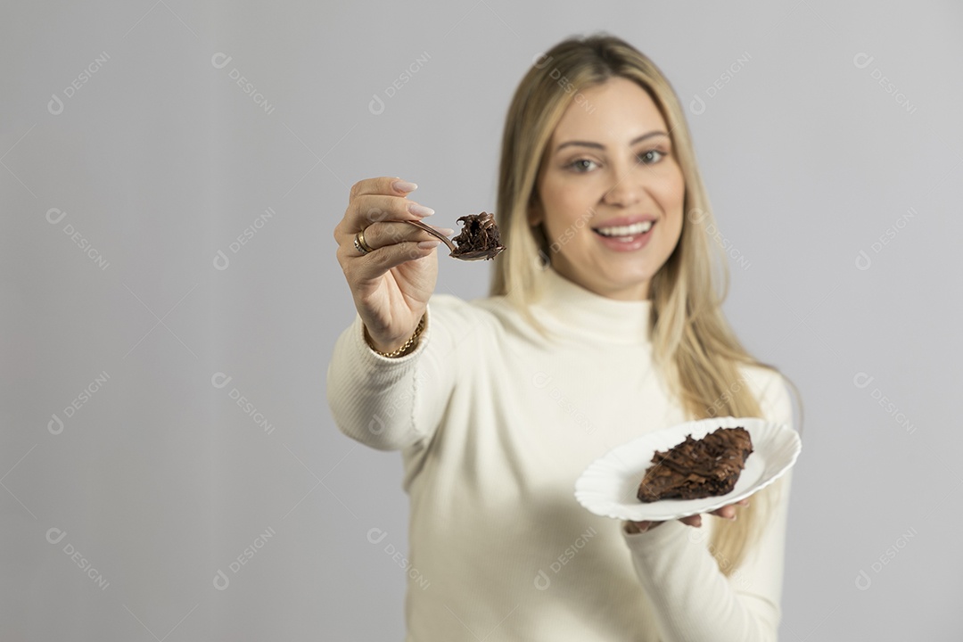 Mulher jovem bonita comendo bolo sobre fundo isolado branco