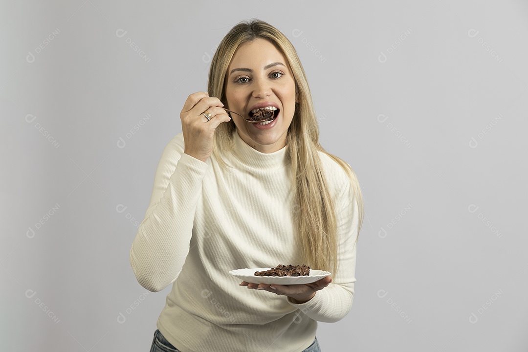Mulher jovem bonita comendo bolo sobre fundo isolado branco