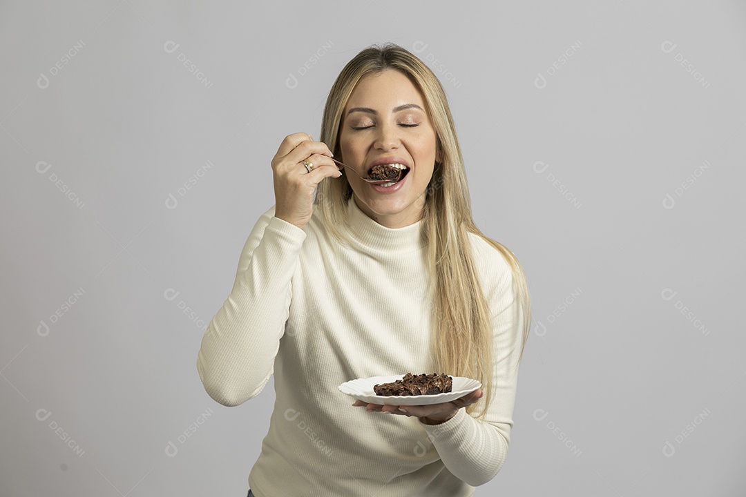 Mulher jovem bonita comendo bolo sobre fundo isolado branco