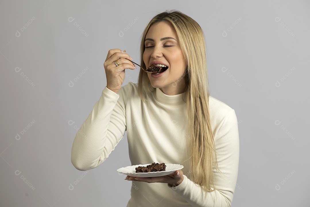 Mulher jovem bonita comendo bolo sobre fundo isolado branco