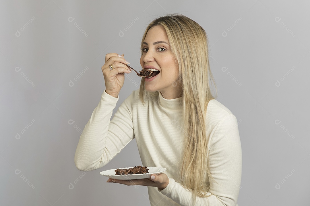 Mulher jovem bonita comendo bolo sobre fundo isolado branco