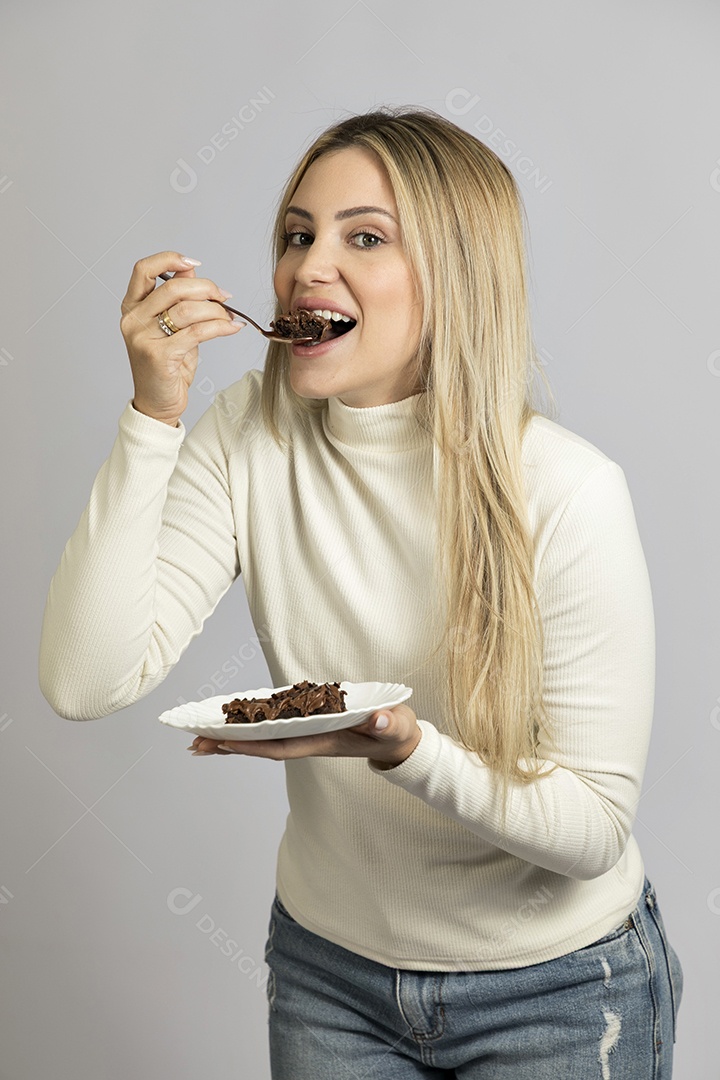 Mulher jovem bonita comendo bolo sobre fundo isolado branco