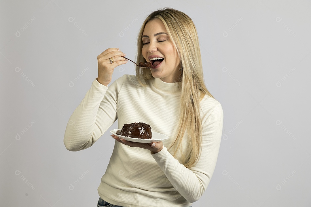 Mulher jovem bonita comendo bolo sobre fundo isolado branco