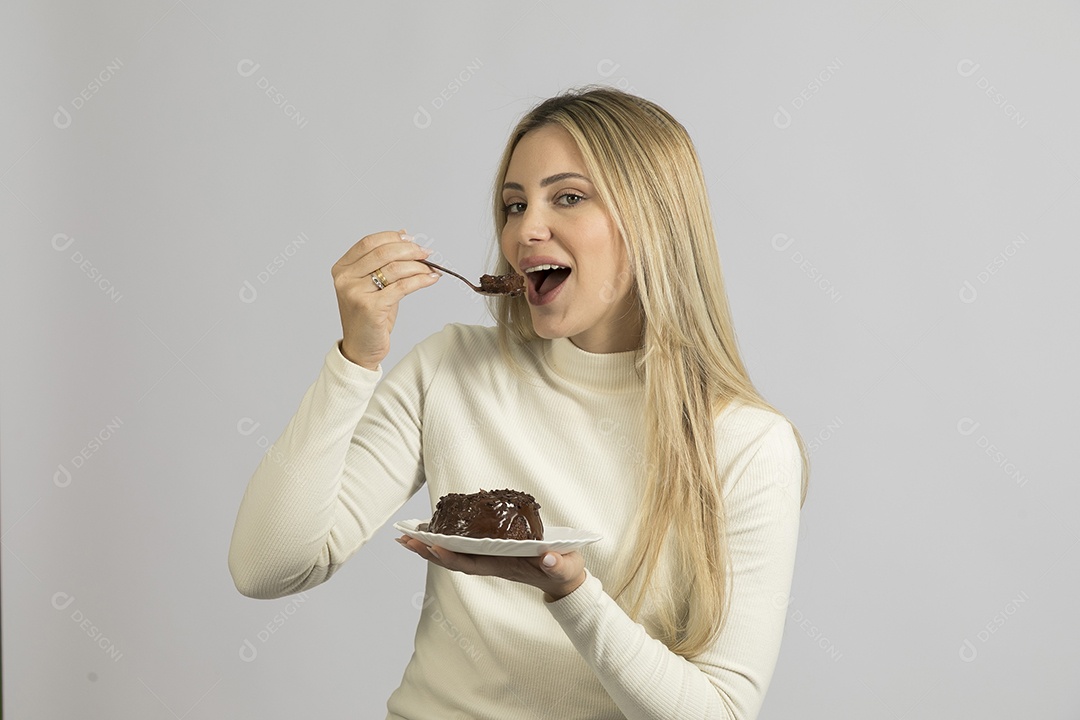 Mulher jovem bonita comendo bolo sobre fundo isolado branco
