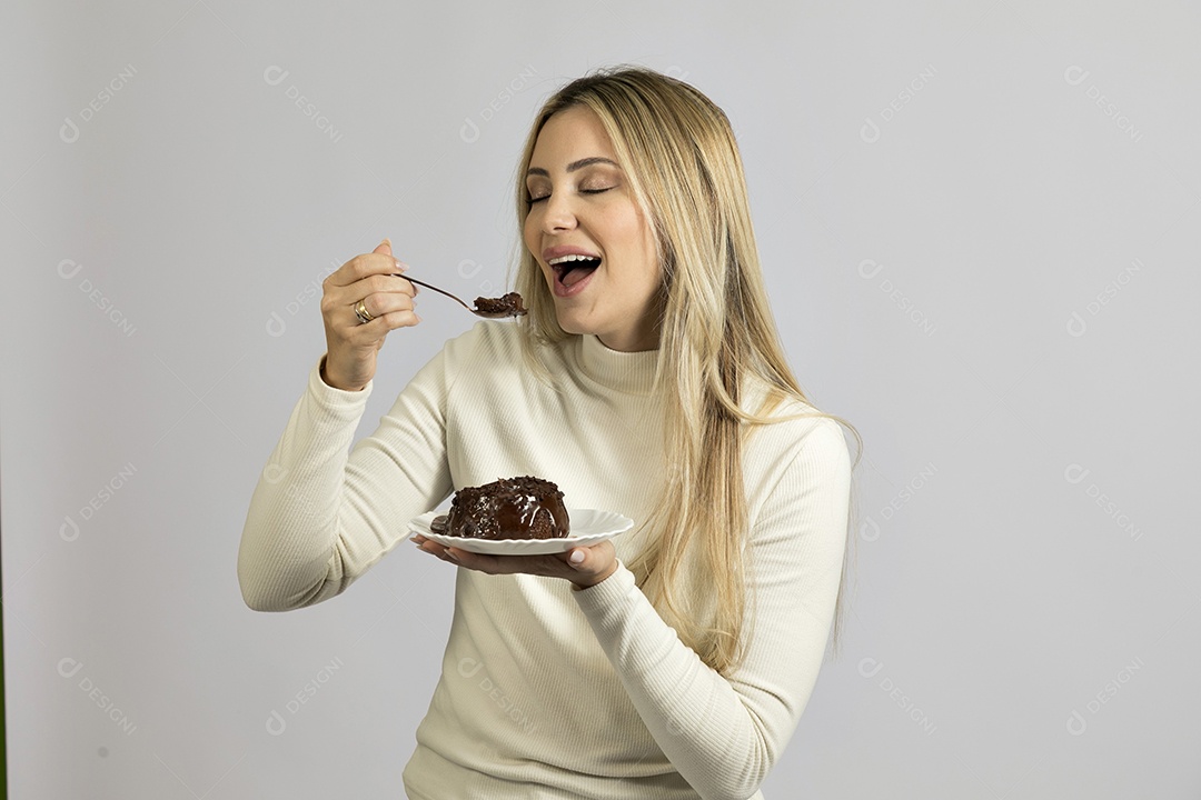 Mulher jovem bonita comendo bolo sobre fundo isolado branco